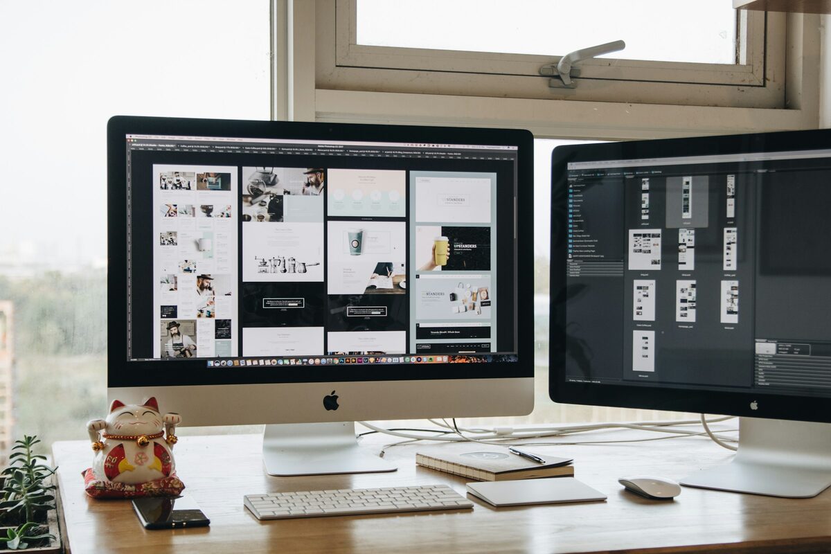 Two screens showing page layouts on a designer's desk